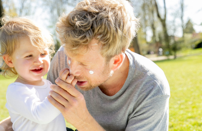 Kind cremt Papa mit mineralischer Sonnencreme von das boep ein