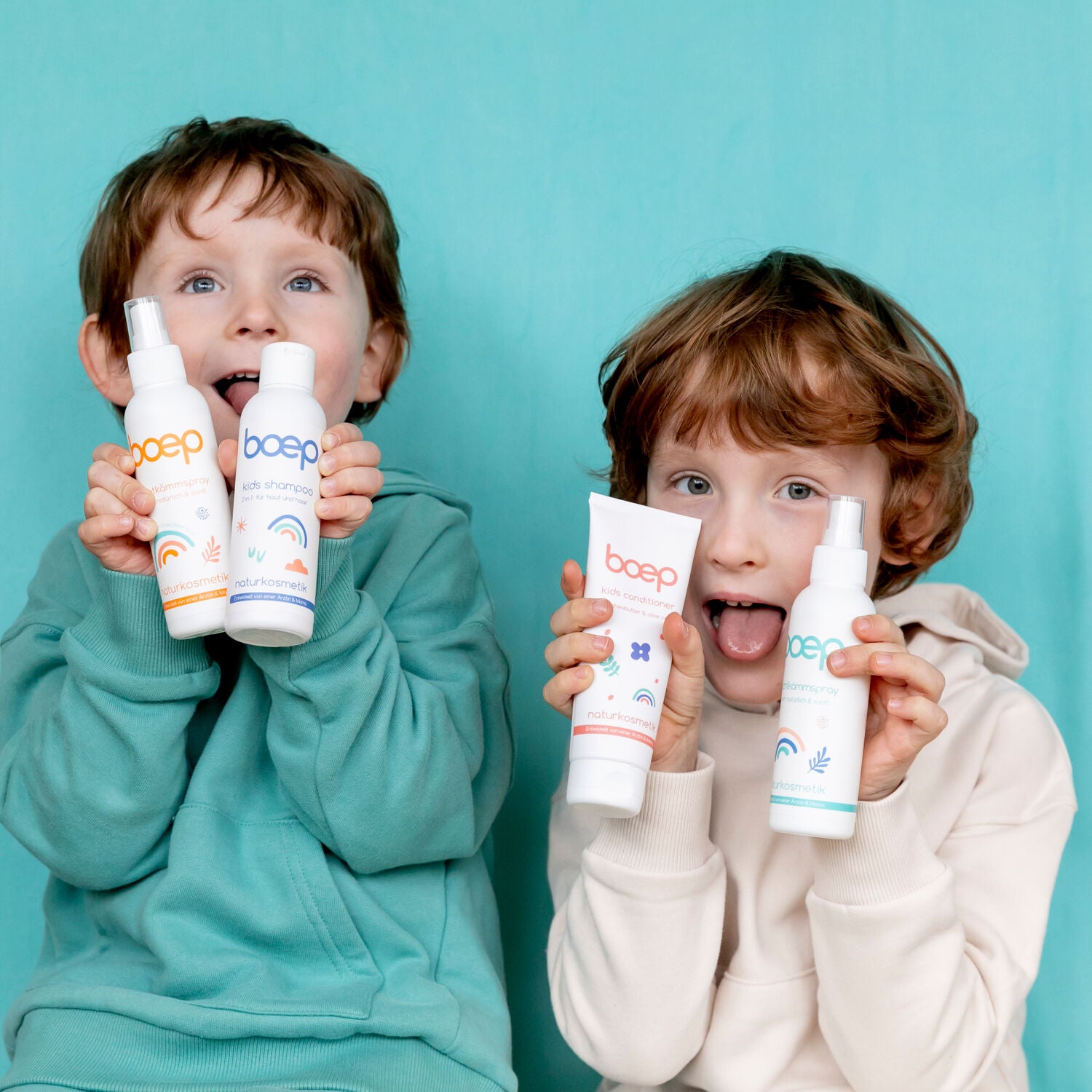 Zwei Jungs mit den Kids Produkten von das boep vor türkisem Hintergrund