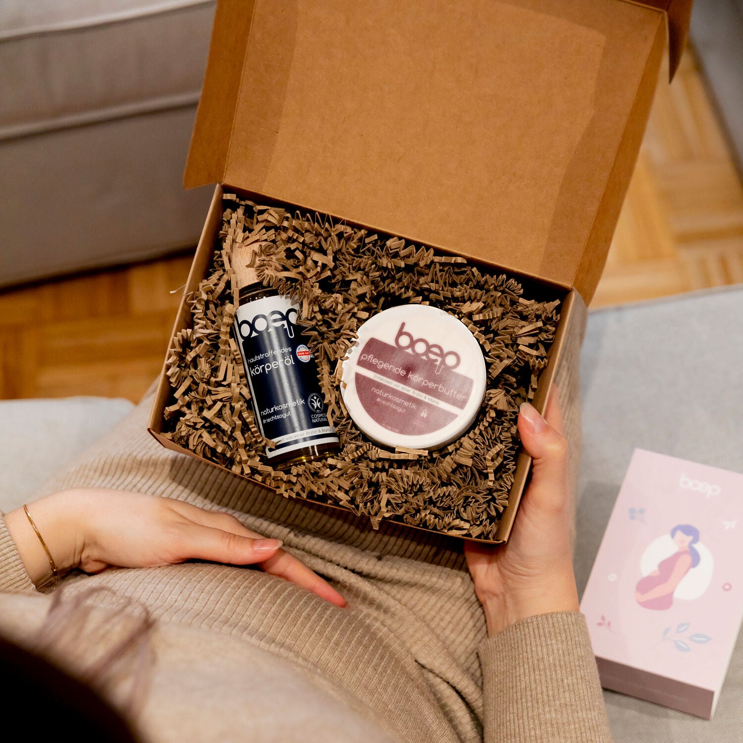 Schwangere Frau mit Geschenkset von das boep mit pflegender Körperbutter und hautstraffendem Körperöl und einer Geschenkbox