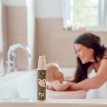 Mutter badet ihr Baby mit dem Babybadeöl, einem pflegenden Badezusatz von das boep für Babys gegen trocken Babyhaut.