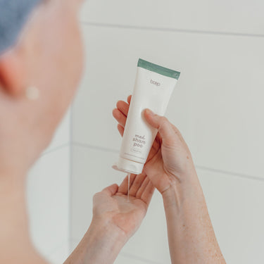 Frau macht sich das med Shampoo, das Naturkosmetik Shampoo ohne Silikone von das boep für empfindliche Kopfhaut in die Hand, um die Konsistenz zu zeigen.